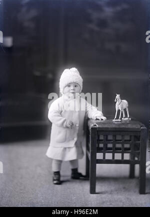 Antike 1900 Foto, Kleinkind Mädchen mit Pferd Spielzeug. QUELLE: ORIGINAL FOTONEGATIV. Stockfoto