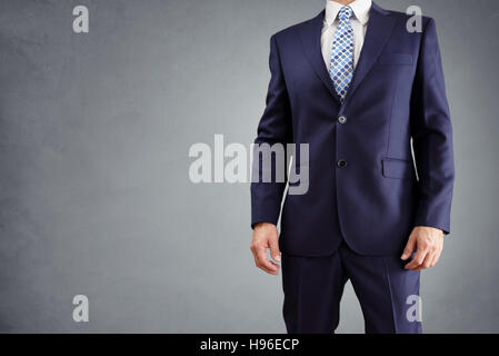 Geschäftsmann im Anzug auf grauem Hintergrund isoliert Stockfoto