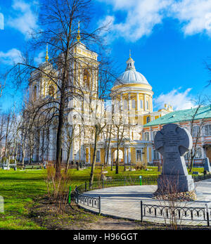 Die Gedenkstätte Kreuz im Garten von Alexander Nevsky Lavra und Holy Trinity Cathedral hinter den Bäumen Stockfoto