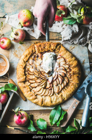 Hand des Mannes halten Stück hausgemachten Apfelkuchen crostata Stockfoto