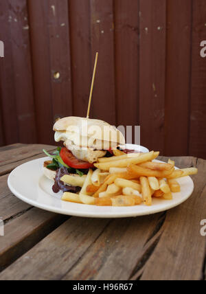 Hamburger mit Pommes Frites und Ketchup, rustikalen Holztisch, Fast-food Stockfoto