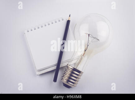 Draufsicht der weißen schwarzen Stift leeren Notebook und eine große Glühbirne Stockfoto