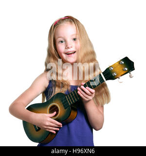 kleines Mädchen in lila Kleid spielen der Ukulele gegen weiße Studio-Hintergrund Stockfoto