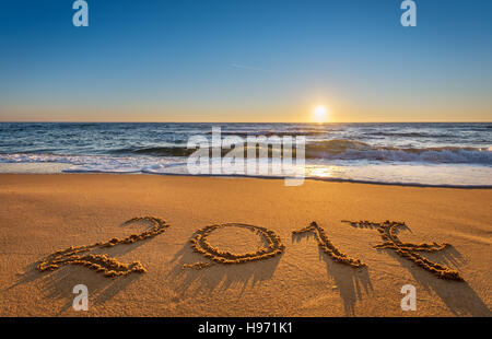 Anzahl 2017 geschrieben am Strand Sand bei Sonnenaufgang. Konzept der kommenden Neujahr und im Laufe der Zeit. Stockfoto