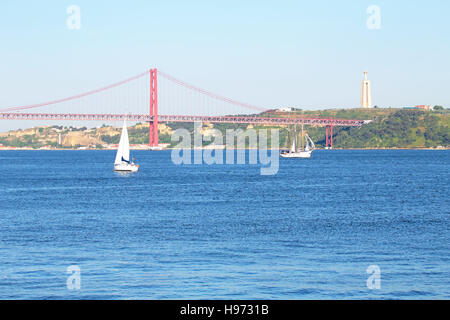 Segeln auf dem Fluss Tejo mit der 25 Abril Brücke und der Christo Rei in Lissabon Portugal Stockfoto