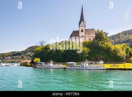 Maria Worth, Österreich - 14. August 2016: Vintage Ausflugsboote an die Kirche von Maria Wörth Passagiere warten. Heilige Primus und Felician-Kirche in Stockfoto