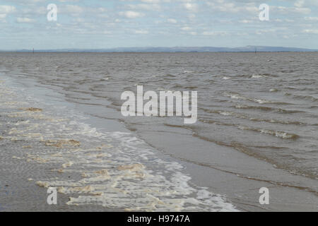 Meerschaum am Sandstrand, steigende Flut Kanal Fluss Ribble Mündung stromaufwärts zu West Pennines, Fairhaven, Lytham St Annes, UK Stockfoto