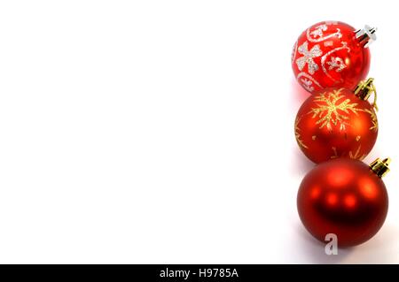 Drei rote Weihnachtskugeln set vertikal auf der rechten Seite auf einem weißen Hintergrund Stockfoto