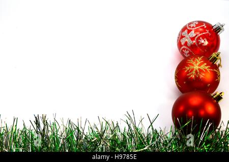 Drei Weihnachtskugeln und einem grünen Kranz vertikal direkt auf einem weißen Hintergrund platzieren Stockfoto