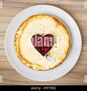 Delicious runden Käsekuchen mit Himbeer-Herzen auf den weißen Teller. Süße Speisen. Stockfoto