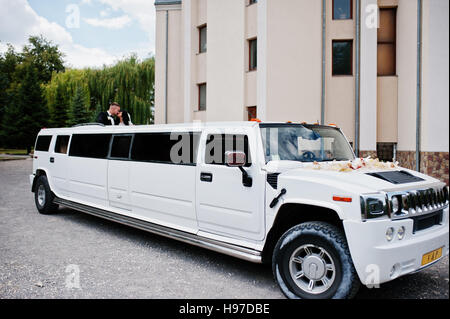 Kiew, Ukraine - 31. August: Eleganz weiße Hochzeit Limousine Hummer H2 mit Brautpaar auf Auto Schiebedach am Hochzeitstag. Stockfoto