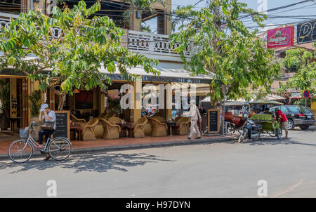 Menschen in Siem Reap Kambodscha zu Fuß durch die Straßen während der tut tut das lokalen Motorrad-Taxi wartet auf Kunden Stockfoto