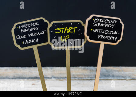 Konzept-Nachricht START UP mit Kreide auf hölzernen Mini Tafel Etiketten, defokussierten Tafel und Holztisch im Hintergrund geschrieben Stockfoto