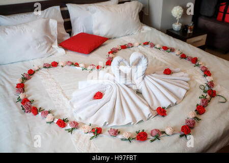 Zwei Schwäne Handtücher bilden Herzform auf Bett gemacht Stockfoto