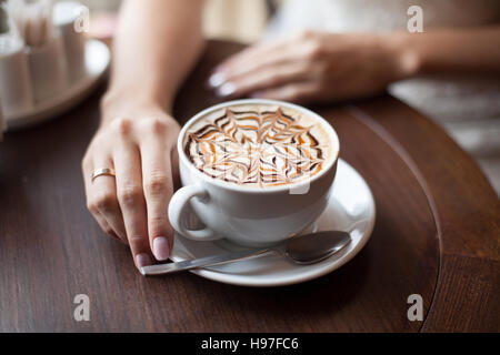 Hände der Braut mit Latte Art Kaffee Tasse. Selektiven Fokus Stockfoto