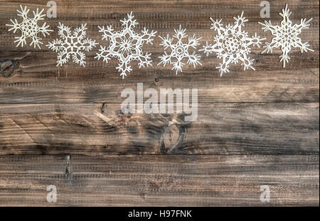 Weihnachts-Dekoration. Schneeflocken-Grenze auf rustikalen hölzernen Hintergrund Stockfoto