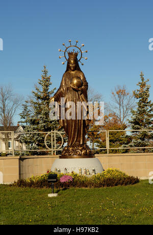 Eine Nahaufnahme einer Bronzestatue der Mutter Mary am Eingang des katholischen Friedhof. Stockfoto