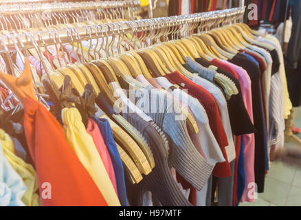 Modekleidung auf Kleiderbügeln auf der Messe. Stockfoto