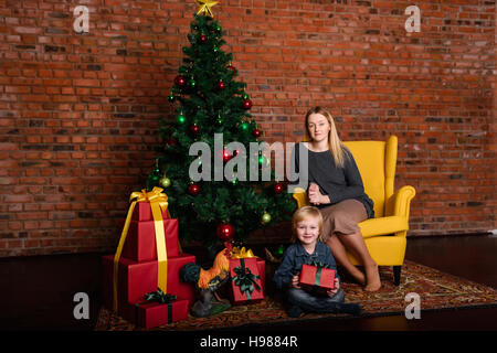 MOM gibt ein Kind Weihnachtsgeschenk Stockfoto