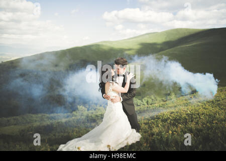 Schöne Hochzeitspaar küssen und umarmen in der Nähe von Berg mit perfekten Blick Stockfoto