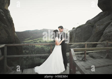 Hochzeitspaar in Liebe küssen und umarmen in der Nähe von Felsen auf schöne Landschaft Stockfoto