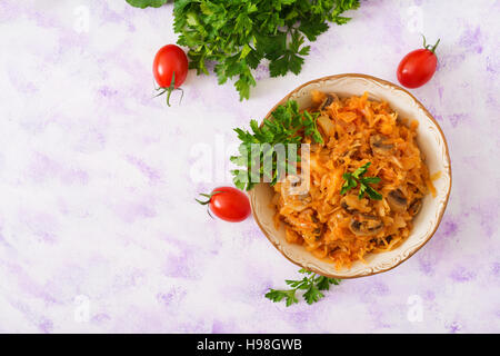 Geschmorte gedünstetem Kohl mit Pilzen in Tomatensauce. Ansicht von oben Stockfoto