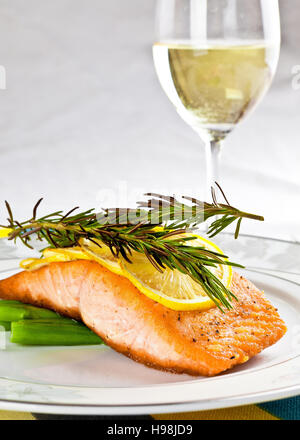Gegrillter Lachs Spargel auf einem weißen Teller mit einem Glas Champagner Stockfoto