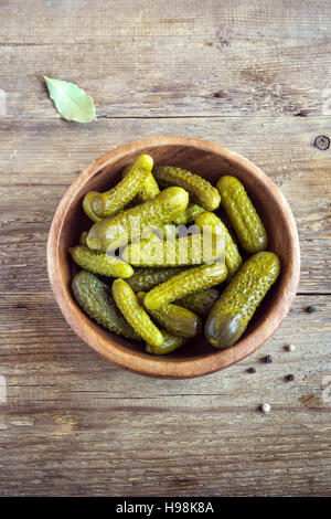 Eingelegtes Gemüse. Schüssel mit Essiggurken (Gurken) über rustikalen hölzernen Hintergrund mit Textfreiraum. Stockfoto