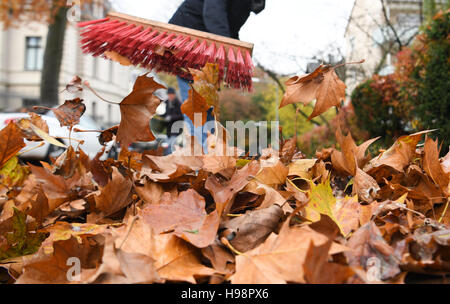 Eine Frau fegt Laub auf einem Bürgersteig in Wiesbaden, Deutschland, 17 November 2016-die Bürgerinitiative "Gehwegreinigung in Bürgerhand" (lit. Bürgersteig Reinigung in Händen der Bürgerinnen und Bürger) entsteht derzeit ein Konzept für eine neue Charta der Straßenreinigung. Die Politik im Bereich der neuen Charta entscheidet bis Mitte des nächsten Jahres, nachdem starke Bürger Widerstand der städtischen Pläne für Straßenreinigung gestoppt. Foto: ARNE DEDERT/dpa Stockfoto