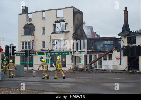 Feuerwehrleute besuchen nach einem Großbrand in einem Gebäude in Bognor Regis, Sussex, UK. Stockfoto