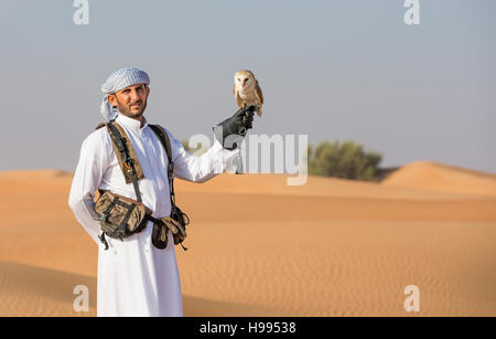 Dubai, Vereinigte Arabische Emirate, 19. November 2016: Ein Falkner in traditioneller Kleidung, Ausbildung eine Schleiereule (Tyto Alba) Stockfoto