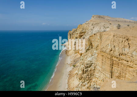 Beeindruckende Klippen mit türkisfarbenen Meer an der Küste in Caotinha, Angola. Gelbe Sandstein fällt steil hinunter zum Meer hier. Stockfoto