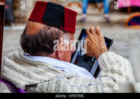 Ein älterer marokkanischen Mann betrachtet man ein Tablet-Gerät, die Medina, Chefchaouen, Marokko Stockfoto