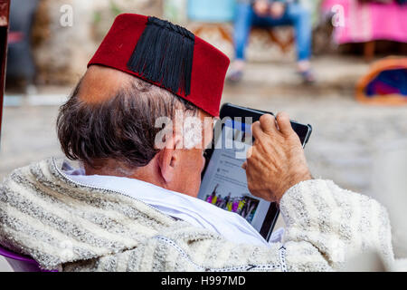 Ein älterer marokkanischen Mann betrachtet man ein Tablet-Gerät, die Medina, Chefchaouen, Marokko Stockfoto