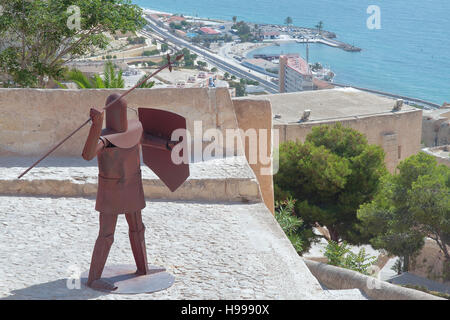 Figur eines Kriegers aus Metall in der Burg von Santa Barbara in Alicante mit der Küste im Hintergrund Stockfoto