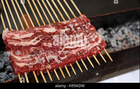 viele rote rohes Fleisch beim Kochen auf die Kohlenpfanne in einem Straßenstand Stockfoto