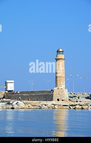 Blick auf den Leuchtturm mit Touristen zu Fuß entlang dem Hafen Wand, Rethymno, Kreta, Griechenland, Europa. Stockfoto