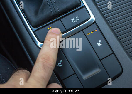 Finger auf Sitz und Lenkung, Heizung steuert. Schuss von modernen Auto Mittelkonsole hautnah. Stockfoto