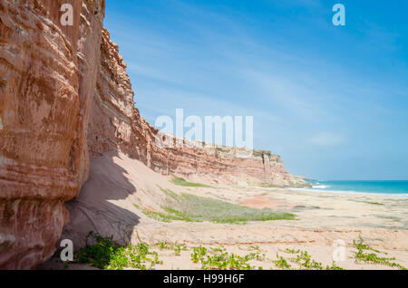 Hoch aufragenden roten Sandsteinfelsen in Angola die Küstenlinie der Namib-Wüste. Stockfoto