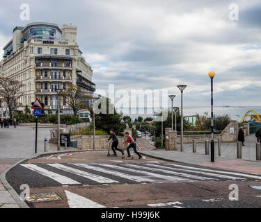 Zwei Jugendliche auf Roller & Fußgängerüberweg vor Park Inn by Radisson. Southend-on-Sea, Essex, England Stockfoto