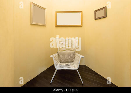Interieur des Zimmers mit alten Mode Sessel und Bild Rahmen im Wohnzimmer. Gelbe Farbe Wohnzimmer. Stockfoto