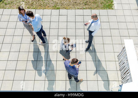 Gruppe von Geschäftsleuten mit Smartphones und Tablets digital im freien Stockfoto