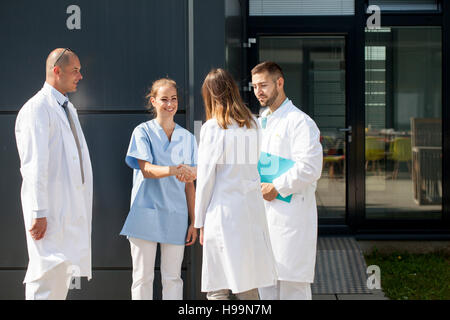 Frau Doktor Händeschütteln mit Krankenschwester im freien Stockfoto