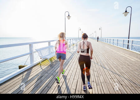 Zwei Frauen Joggen entlang einer Anlegestelle Stockfoto