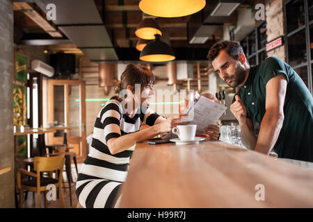 Barkeeper und weiblichen Gast am Tresen Stockfoto