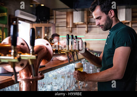 Barkeeper im Café Gießen Bier vom Fass Stockfoto