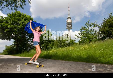 Junge Frau hält europäische Flagge beim Skateboarden Stockfoto