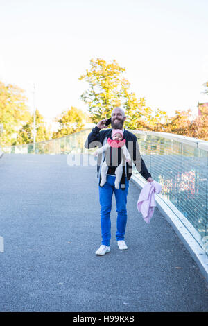 Vater mit Babymädchen in Babytrage Stockfoto