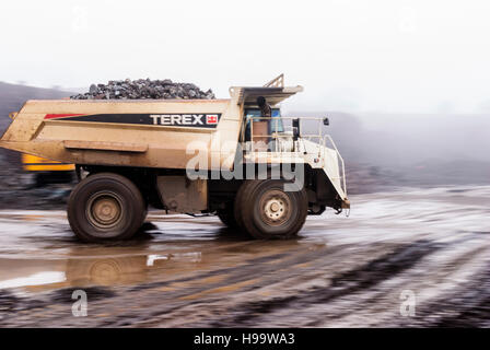 Ein Muldenkipper Terex Rock dauert eine volle Ladung aus Stein in einem Steinbruch bei starkem Regen. Stockfoto