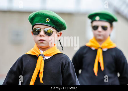 Belfast, Nordirland. 13. November 2016 - Kinder in pseudo-paramilitärischen Uniformen, darunter grüne Basken, orangefarbene Halsschals, weiße Hemden, schwarze Pullover und Spiegelbrillen, nehmen an einer Parade der irischen Republikaner Teil Stockfoto